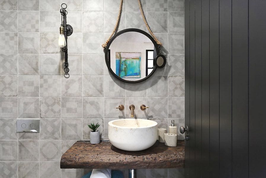 Powder room with round mirror and vessel basin